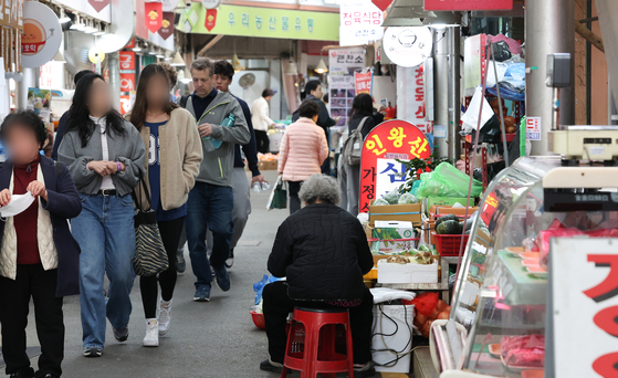 Shoppers walk past vendors at a traditional market in Jongno District, central Seoul, on April 15. The Korean government announced a supplementary budget aimed at addressing urgent national priorities including small business support on April 18. [NEWS]