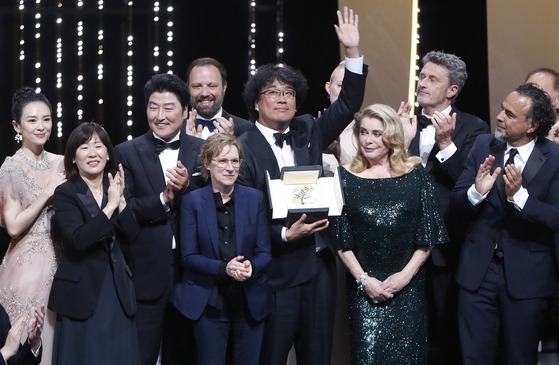 Director Bong Joon-ho, center, winner of the Palme d'Or for the film ″Parasite″ (2019), stands on stage with his award during the Closing Awards Ceremony of the 72nd Cannes Film Festival, in Cannes, France, on May 25, 2019. [EPA/YONHAP]