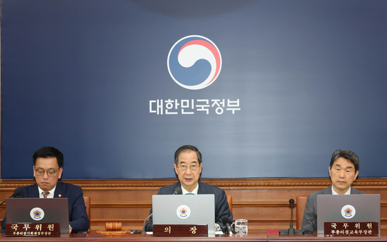 Acting President Han Duck-soo, left, and Minister of Economy and Finance Choi Sang-mok, center, speaks during a Cabinet meeting to review the supplementary budget plan for this year at the government complex in Jongno District, central Seoul on April 18. [JOINT PRESS CORPS]
