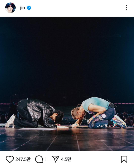 Jin of boy band BTS and Coldplay vocalist Chris Martin bow to each other on April 19 at Coldplay's concert held in Goyang, Gyeonggi. [SCREEN CAPTURE]