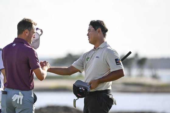 Kim Si-woo, right, and Justin Thomas shake hands on the 18th hole green during the third round of the RBC Heritage at Harbour Town Golf Links on April 19 in Hilton Head Island, South Carolina. [GETTY IMAGES]