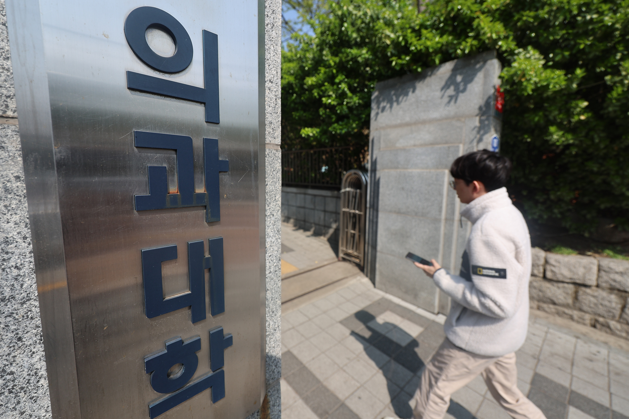 A student walks into the campus of a medical school in Seoul on April 16. [YONHAP]