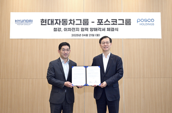 Han Seok-won, executive vice president and head of strategy and planning at Hyundai Motor Group left, and Posco Holdings President Lee Joo-tae pose for a photo at an MOU signing at Hyundai Motor’s offices on Monday.