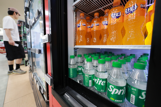 Bottles of Spirte and Fanta are stacked in a refrigerator at a market in Seoul on April 21. [YONHAP] 