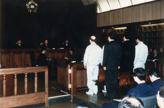 Former Presidents Chun Doo Hwan, left, and Roh Tae-woo, who were indicted on charges including insurrection, murder for insurrectional purposes, and bribery related to the Dec. 12 coup and the May 18 Gwangju Uprising, stand at the defendant’s bench on March 11, 1996. [JOONGANG ILBO]