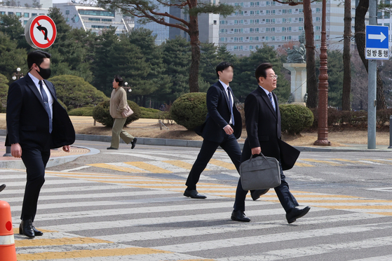 Lee Jae-myung, a presidential primary candidate for the liberal Democratic Party, walks with a security detail at Yeouido, western Seoul, on March 17. [YONHAP]