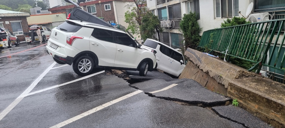 Cars lie damaged after a retaining wall collapsed in the ground-level parking lot of an apartment complex in Namyangju, Gyeonggi, on April 22. [GYEONGGI-DO FIRE SERVICES]