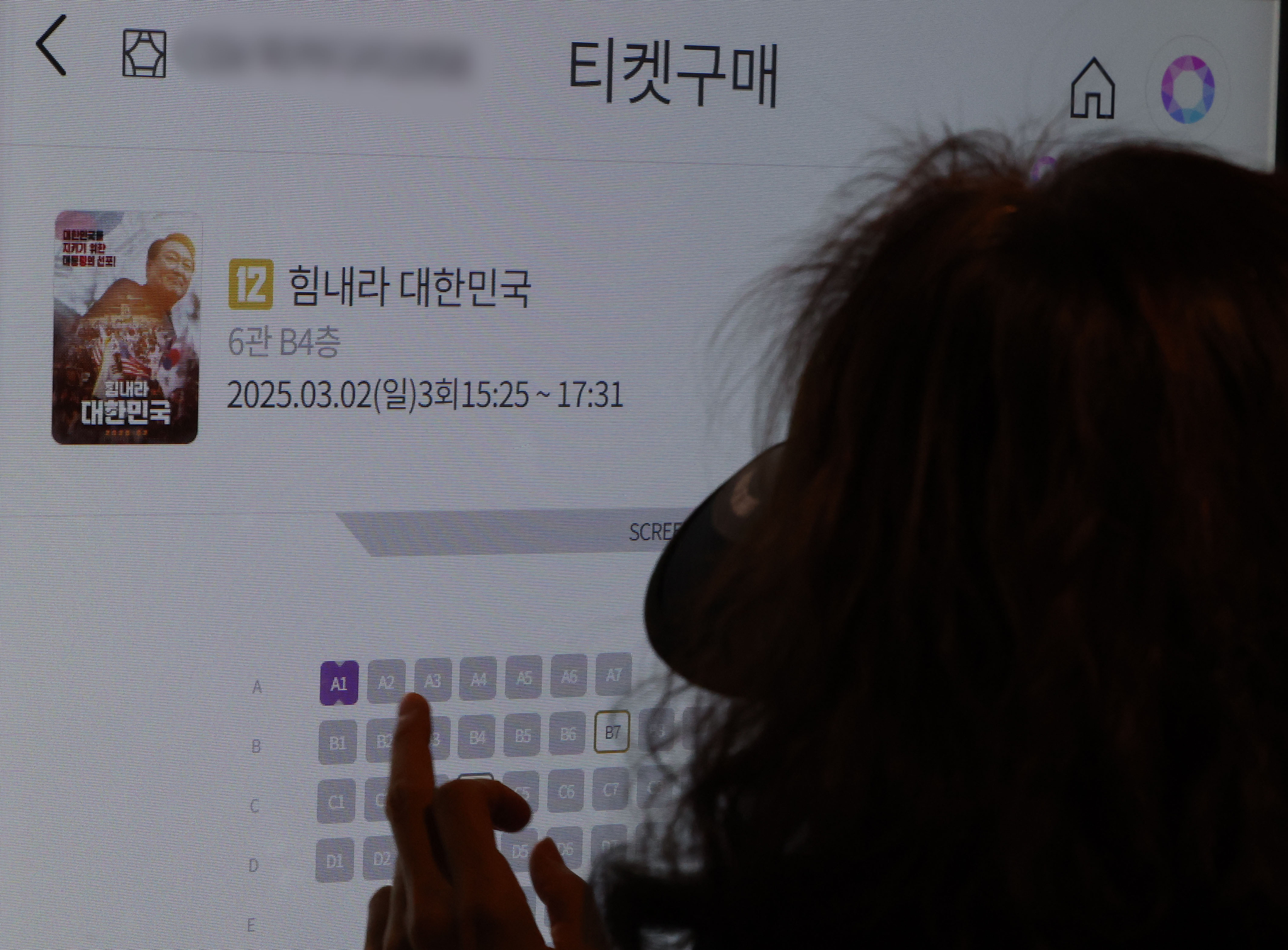 A moviegoer buys tickets at a theater in Seoul on March 2. [NEWS1]