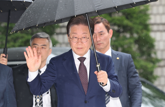 Democratic Party presidential front-runner Lee Jae-myung waves to supporters in front of Seoul Central District Court in Seocho District, western Seoul, on April 22. [NEWS1]