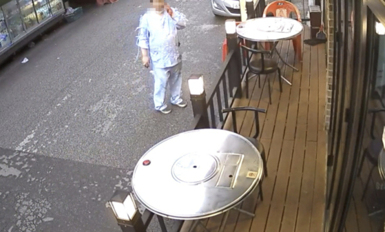 The 33-year-old man who is accused of fatally stabbing a woman in her 60s is seen smoking outside a supermarket shortly before the incident happened on April 22, in this CCTV footage. [SHIN HYE-YEON]