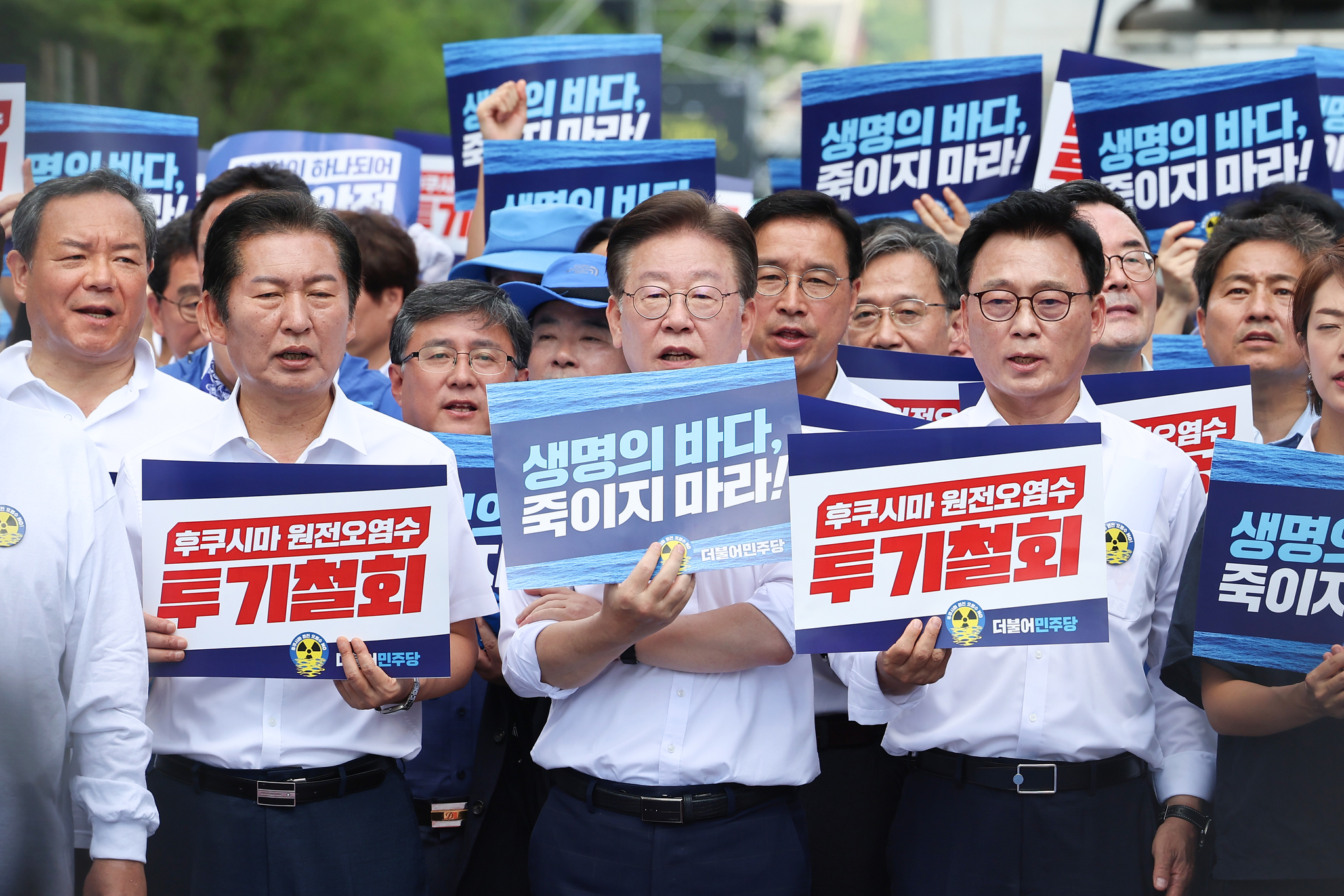 Rep. Lee Jae-myung, center, and other members of the Democratic Party hold up placards calling on Japan to stop releasing treated wastewater from the ruined Fukushima nuclear power plant during a rally in Jongno District, central Seoul, on Aug. 25, 2023. [YONHAP]
