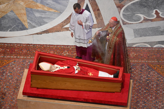 The Vatican's camerlengo, Cardinal Kevin Joseph Farrell, right, diffuses incense next to the body of Pope Francis lies in state at St. Peters Basilica, in Vatican City on April 23. [EPA/YONHAP] 