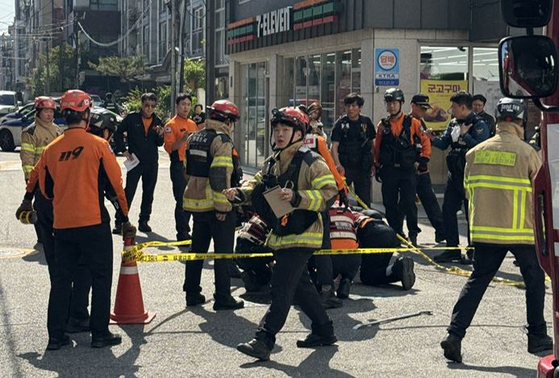 Emergency responders investigate the site where a sinkhole 20 centimeters (8 inches) wide and 1.35 meters deep opened on a road in Yeoksam-dong, Gangnam District in southern Seoul at around 3:16 p.m. on April 25.[YONHAP]