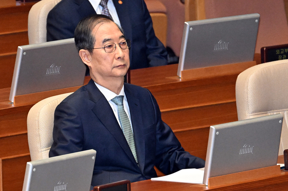 Acting President Han Duck-soo waits to deliver the government's policy speech on the first supplementary budget for 2025 at the National Assembly in western Seoul on April 24. [JOONGANG ILBO]