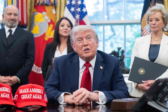 U.S. President Donald Trump speaks to media after signing executive orders related to higher education, alongside U.S. Commerce Secretary Howard Lutnick, left, and Education Secretary Linda McMahon in the Oval Office of the White House in Washington on April 23. [AFP/YONHAP]