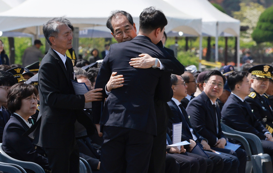 Acting President Han Duck-soo hugs Lee Hwa-joo, the brother of the late Private Lee Chung-joo, during a memorial ceremony for fallen military and police conscripts at Daejeon National Cemetery in Daejeon on April 25. [YONHAP]