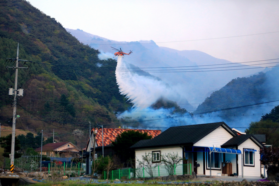 A firefighting helicopter works to extinguish a wildfire in Inje County, Gangwon, on April 26. [NEWS1]