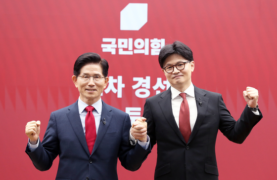 People Power Party candidates Kim Moon-soo, left, and Han Dong-hoon, right, pose for a photo at the party headquarters in Yeouido in western Seoul after the announcement of the final round of candidates on April 29. [JOINT PRESS CORPS] 