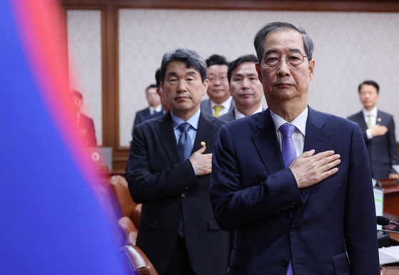 Acting President and Prime Minister Han Duck-soo pledges allegiance to the Korean flag before a Cabinet meeting held at the government complex in Jongno District, central Seoul on April 29. [JOINT PRESS CORPS]
