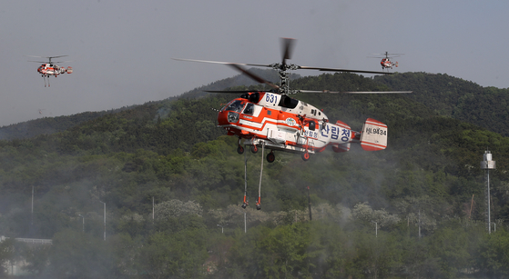 A firefighting helicopter on April 29 fights the fire at Mount Hamji in Daegu that started the day before. [NEWS1] 
