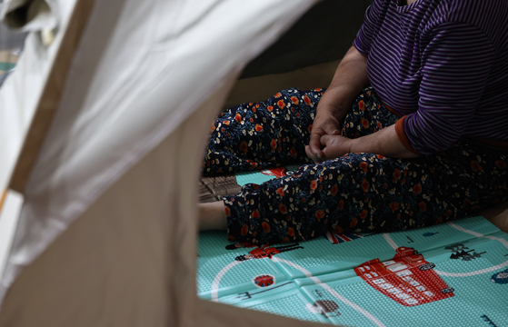 A resident affected by the wildfire on Mount Hamji in Daegu rests at a tent prepared at an evacuation center in Paldal Elementary School in Buk District on April 29. [NEWS1] 