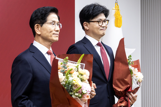 People Power Party candidates Kim Moon-soo, left, and Han Dong-hoon, right, pose for a photo at the party headquarters in Yeouido after the announcement of the final round of candidates on April 29. [JOINT PRESS CORPS]