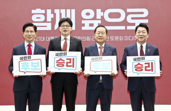 People Power Party presidential primary candidates, from left, Kim Moon-soo, Han Dong-hoon, Hong Joon-pyo and Ahn Cheol-soo hold placards reading “Victory for the People’s Candidate” during a Media Day event following the second-round primary debate at the party’s headquarters in western Seoul on April 23. [JOINT PRESS CORPS]