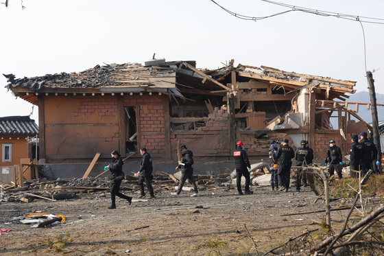 Investigators examine the site of an accidental fighter jet bombing of a village in Pocheon, Gyeonggi, in this file photo taken March 7, one day after the Air Force's two KF-16 fighter jets mistakenly released eight MK-82 air-to-surface bombs outside a training range. [YONHAP]