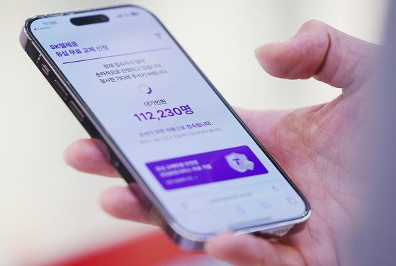 A phone screen shows a cue of over 110,000 people on an online SK Telecom service for SIM replacement on April 28. [YONHAP]