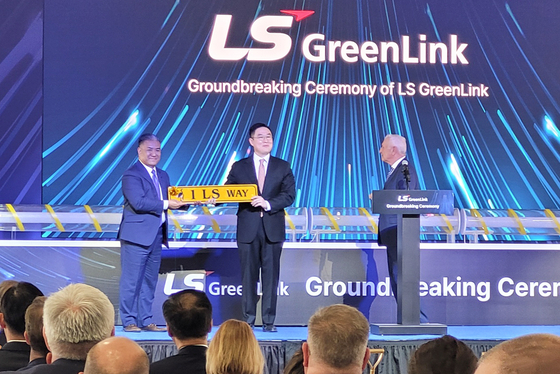 LS Cable & System CEO Koo Bon-kyu, center, holds a street sign reading ″1 LS Way,″ presented by Chesapeake Mayor Rick West, right, in Virgina on April 28. [YONHAP]