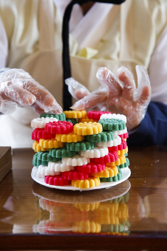 A visitor to the 2025 Spring K-Royal Culture Festival makes goimsang, which is a tower of food served during festivals held in Korean palaces, at the Gyeongbok Palace in Jongno District, central Seoul, on April 26, 2025. [KOREA HERITAGE AGENCY]