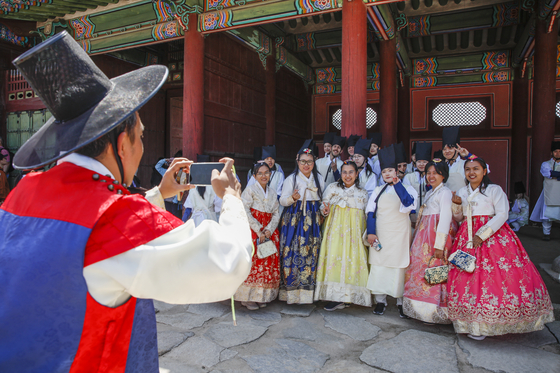 Visitors take pictures in the 2025 Spring K-Royal Culture Festival at the Gyeongbok Palace in Jongno District, central Seoul, on April 26, 2025. [KOREA HERITAGE AGENCY][KOREA HERITAGE AGENCY]