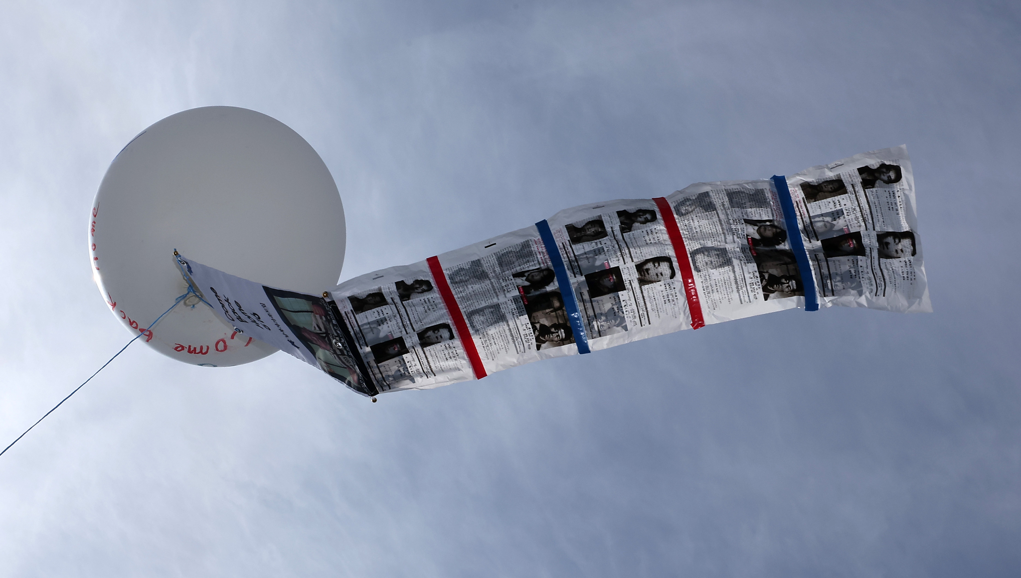 Leaflets aimed at North Korea flutter from a large balloon during the ″Safe Return Memorial Ceremony″ hosted by the Families of Abductees to North Korea Association near Peace Land at Imjingak in Paju, Gyeonggi, on April 23. [NEWS1]