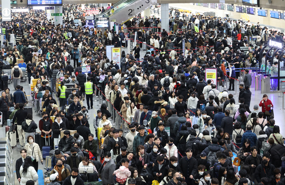Crowds of travelers wait in line to depart at Gimhae International Airport ahead of the Lunar New Year holiday on Jan. 26. [JOONGANG PHOTO]