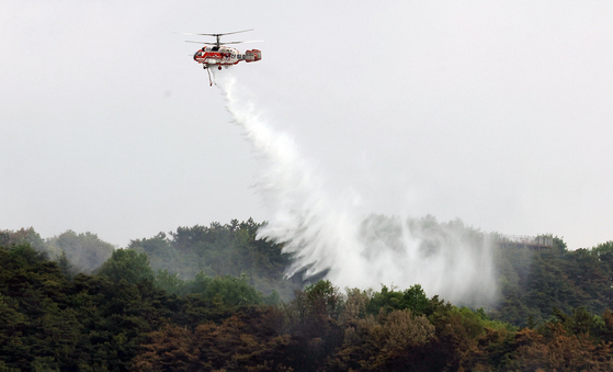 Helicopters from the Korea Forest Service and fire authorities work to extinguish the rekindled wildfire on Mount Hamji in Buk District, Daegu, on May 1, after the fire had been brought under control on April 29. [YONHAP] 