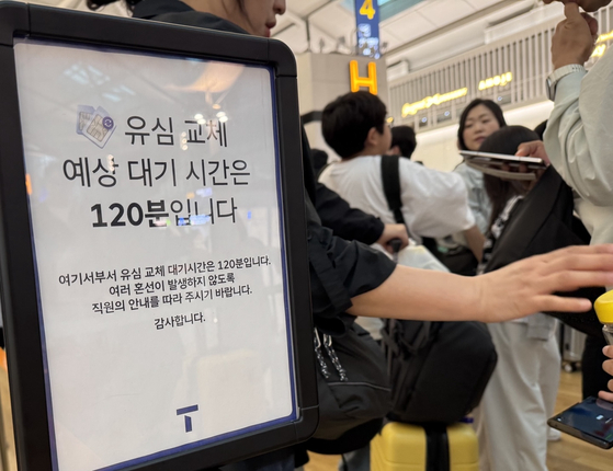 Travelers wait to replace their SIM cards at the SK Telecom roaming center in Terminal 1 of Incheon International Airport in Incheon on May 1. [NEWS1]