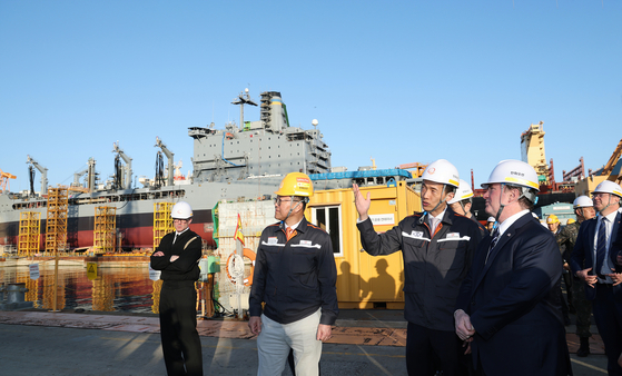 U.S. Secretary of the Navy John Phelan, fourth from left, and Hanwha Group Vice Chairman Dong Kwan Kim, third from left, tour the maintenance site of the USNS Yukon at Hanwha Ocean’s Geoje shipyard on April 30. [HANWHA OCEAN]