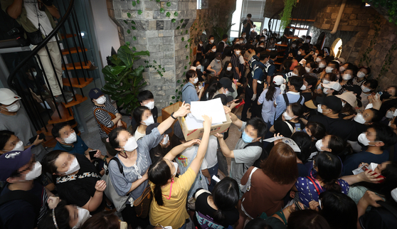 Customers fill the headquarters of Mergeplus on Friday afternoon in Yeongdeungpo, western Seoul, demanding refunds after the company reduced the number of affiliated shops and stopped selling Mergemoney on Aug. 11, 2021. [YONHAP]