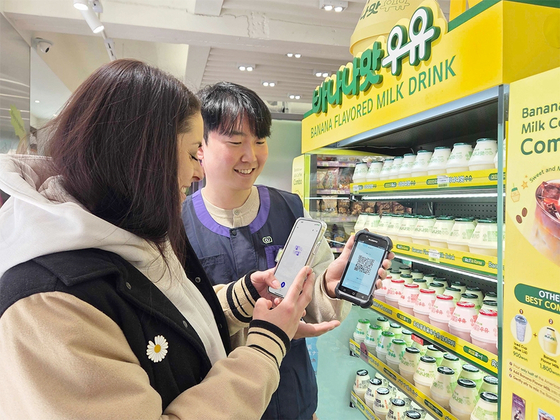A customer operates a PDA-based AI interpretation services in a CU store. [BGF RETAIL] 