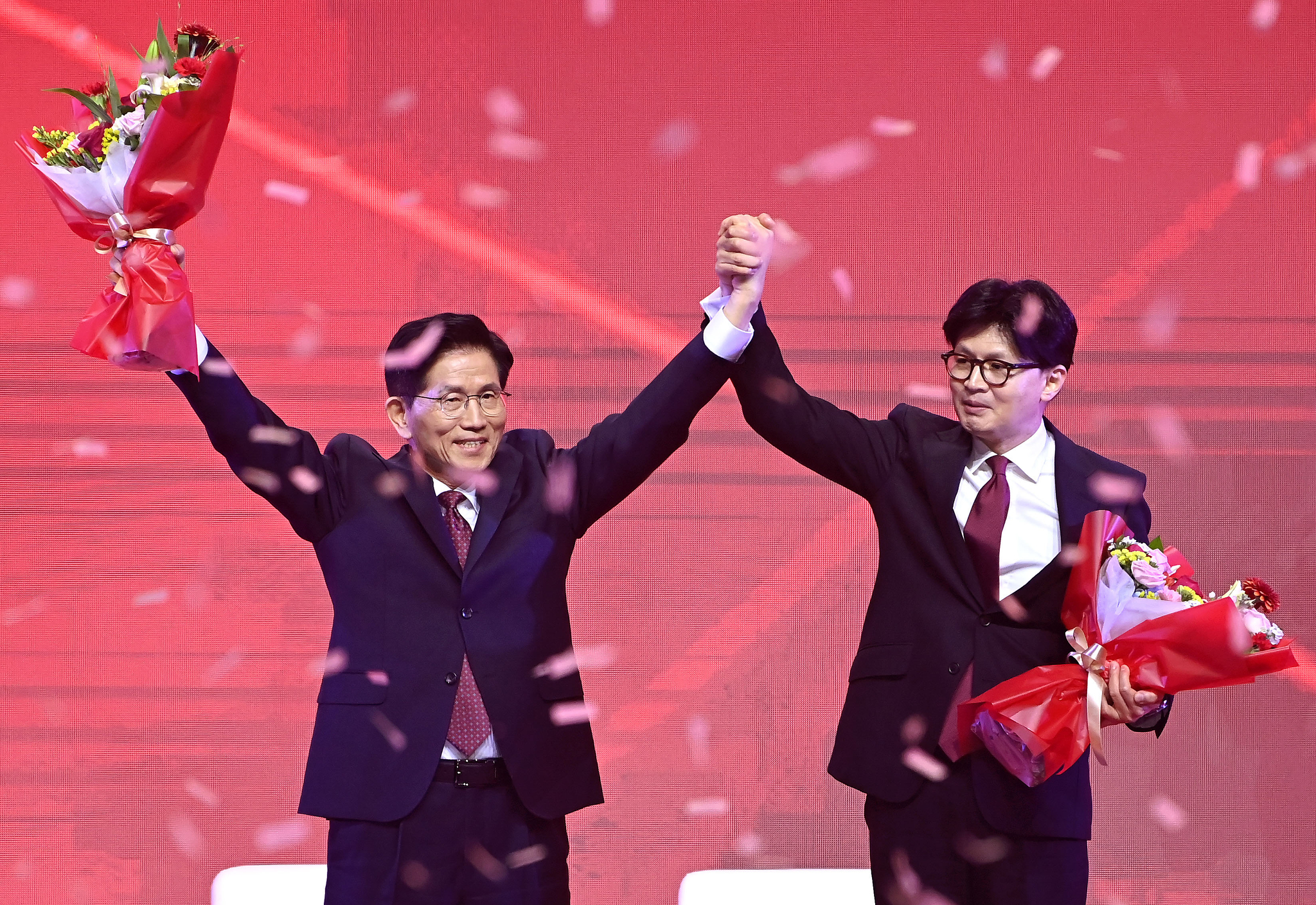 People Power Party candidate Kim Moon-soo, left, raises his hands in celebration after being announced the winner of the party's presidential primaries. Runner-up Han Dong-hoon stands next to him. [IM HYEON-DONG]