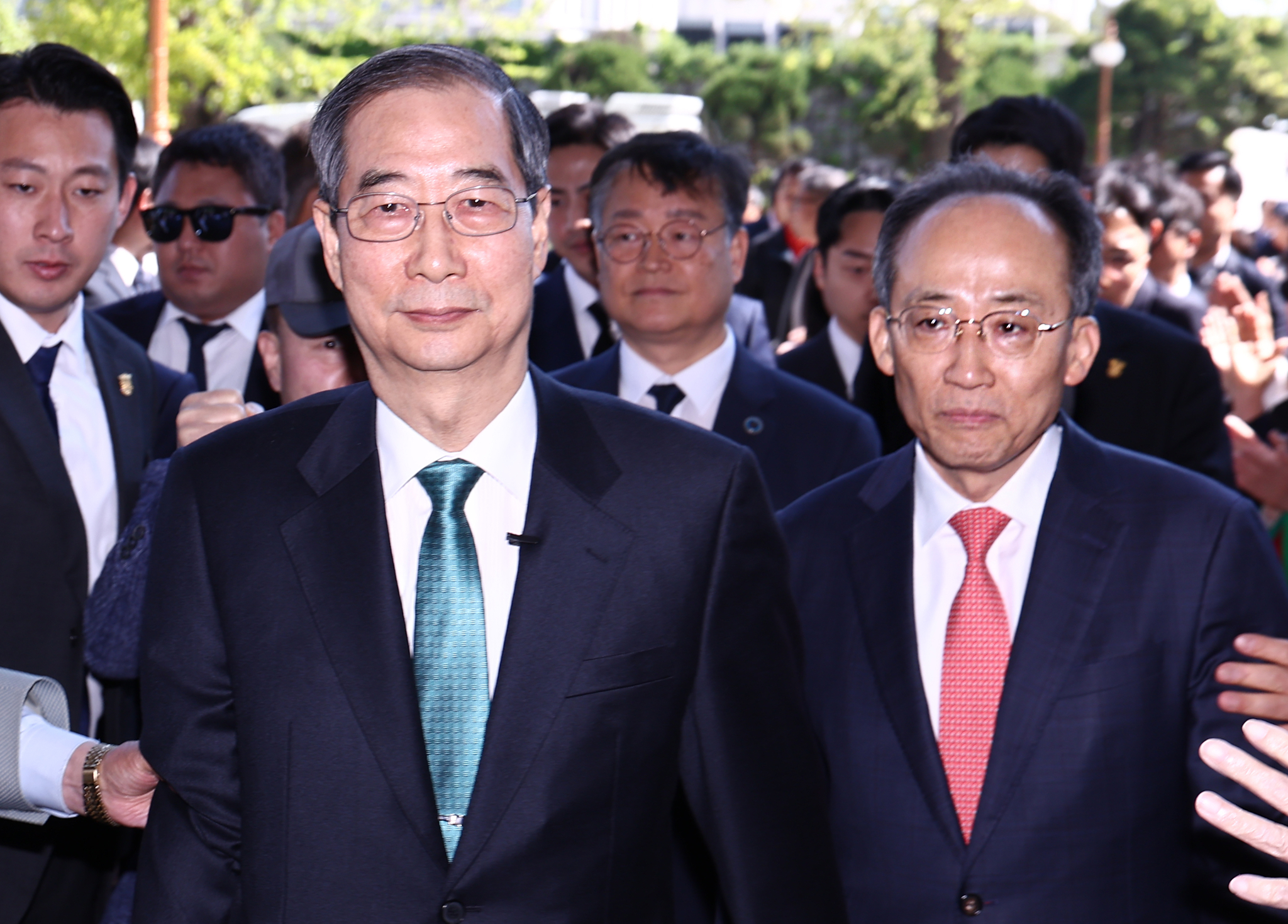 Former Prime Minister Han Duck-soo, left, and conservative People Power Party Rep. Choo Kyung-ho enter the National Assembly building to declare Han's presidential candidacy on May 2 in western Seoul. [NEWS1]