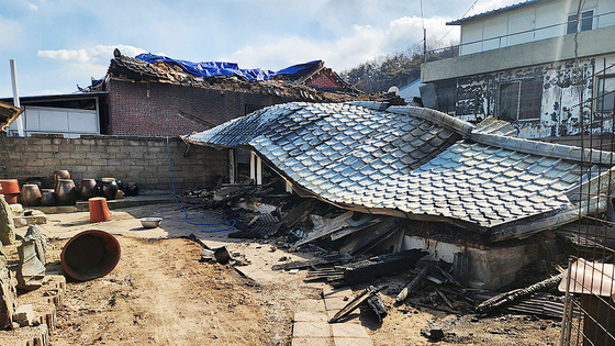 Two days after the wildfire in North Gyeongsang is brought under control, only the roof remains of a house destroyed by the fire in Andong, North Gyeongsang, on April 30. [JOONGANG ILBO]