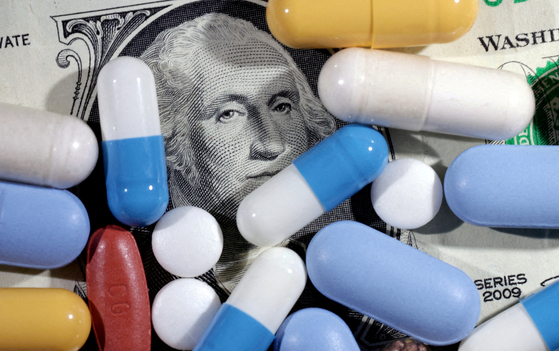 U.S. dollar banknote and medicine are seen in this illustration. [REUTERS/YONHAP]