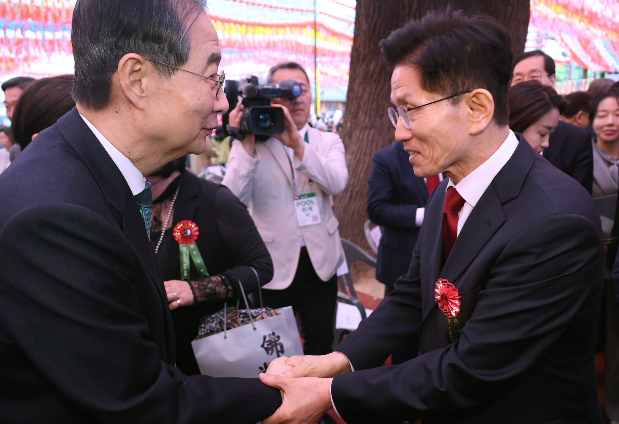 Former Prime Minister Han Duck-soo, left, and People Power Party presidential candidate Kim Moon-soo shake hands at an event for Buddha's Birthday at the Jogye Temple in Jongno District, central Seoul, on May 5, 2025. [JOINT PRESS CORPS] 
