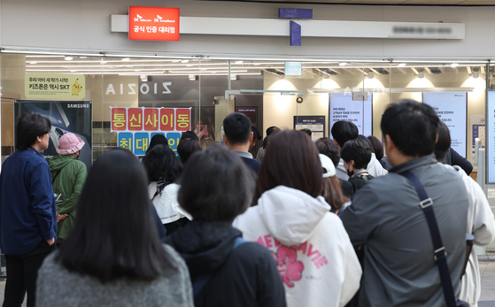 People line up in front of an SK Telecom retail store in Seoul on April 29 to replace their subscriber identity module (SIM) card free of charge. [YONHAP]