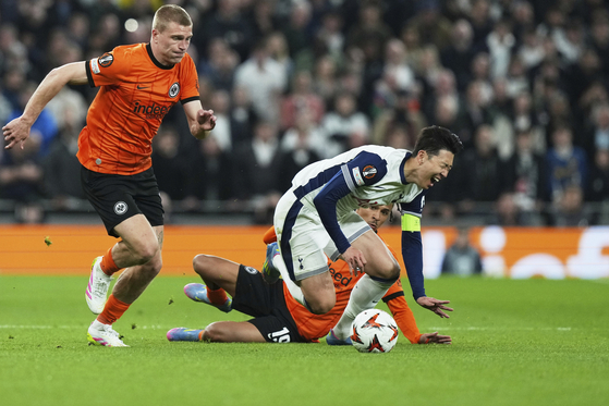 Frankfurt's Jean-Matteo Bahoya, background right, fouls Tottenham's Son Heung-min to see a yellow card during the Europa League quarterfinals first leg match between Tottenham Hotspur and Eintracht Frankfurt at the Tottenham Hotspur Stadium in London, England, on April 10, 2025. [AP/YONHAP]