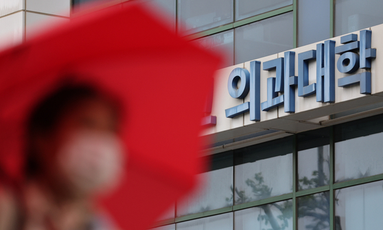 A pedestrian walks by a medical school in downtown Seoul on May 9. [NEWS1]
