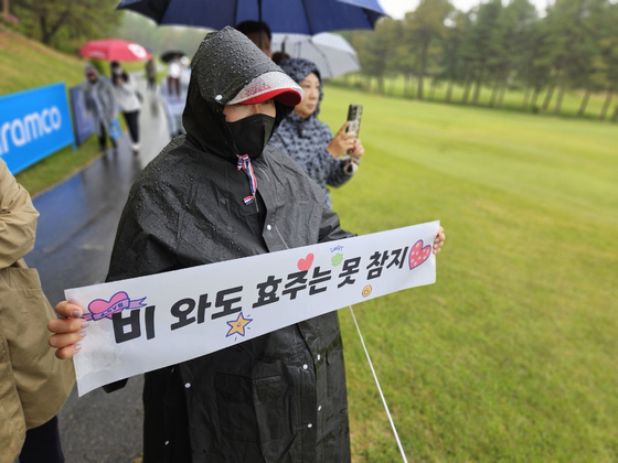 A fan of Kim Hyo-joo holds a sign saying, ″Even if it rains, I can’t resist Hyo-joo,” at the Aramco Korea Championship at New Korea Country Club in Goyang, Gyeonggi, on May 9. [PAIK JI-HWAN]