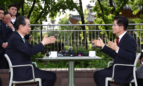 People Power Party presidential candidate Kim Moon-soo, right, and independent candidate Han Duk-soo meet in a cafe at the National Assembly in western Seoul on May 8. [YONHAP] 