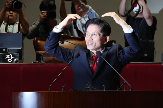 People Power Party (PPP) presidential candidate Kim Moon-soo makes a heart before his speech in the National Assembly’s general meeting room in Yeouido, western Seoul, on May 9. [NEWS1]